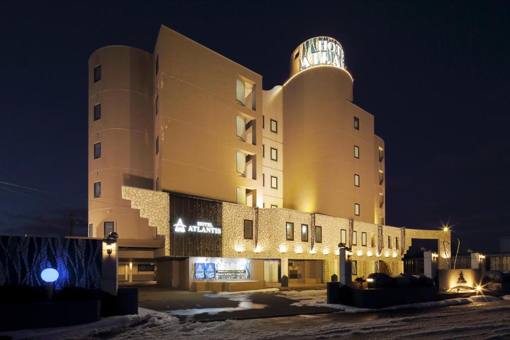 a large building with a clock tower at night at HOTEL ATLANTIS Otaru(Adult Only) in Otaru