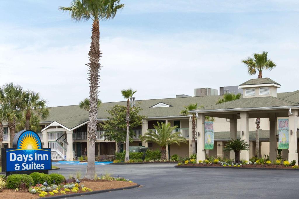 a large palm tree in front of a hotel at Days Inn & Suites by Wyndham Jekyll Island in Jekyll Island