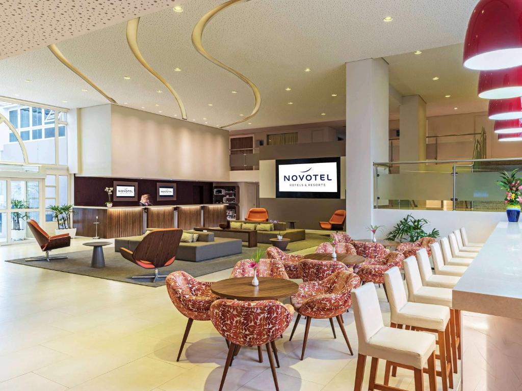 a lobby with a waiting area with chairs and tables at Novotel Manaus in Manaus