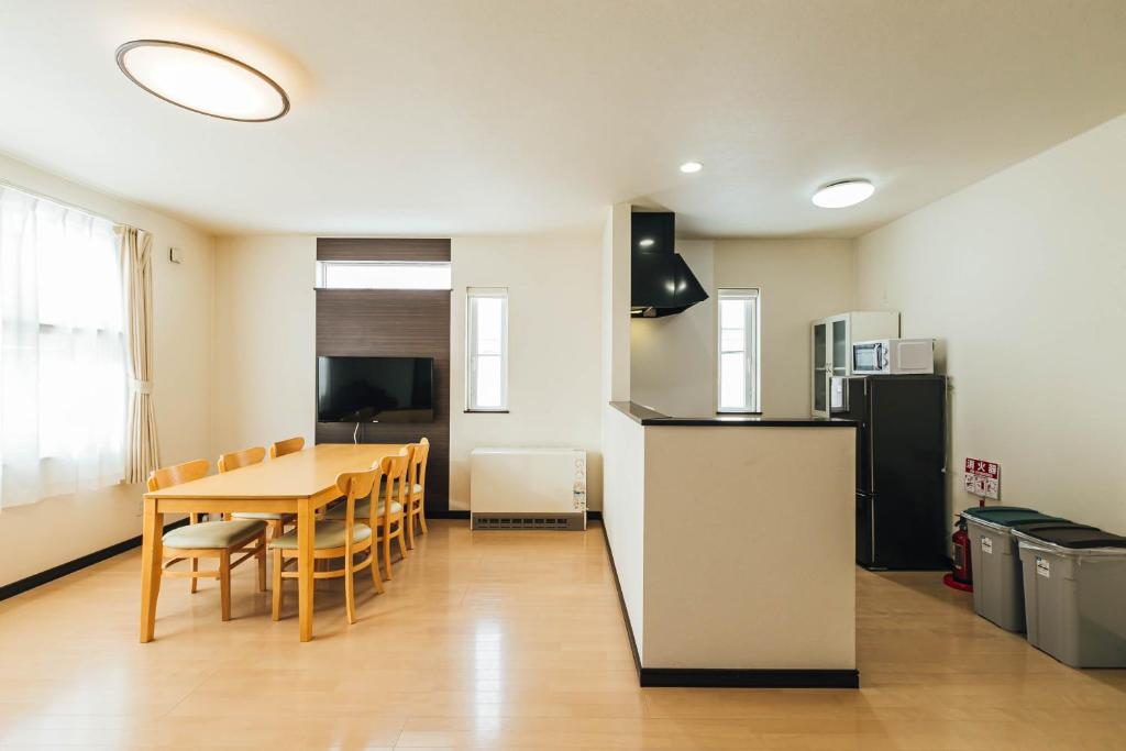 eine Küche und ein Esszimmer mit einem Tisch und einem Kühlschrank in der Unterkunft STAY IN ASAHIBASHI Asahikawa in Asahikawa