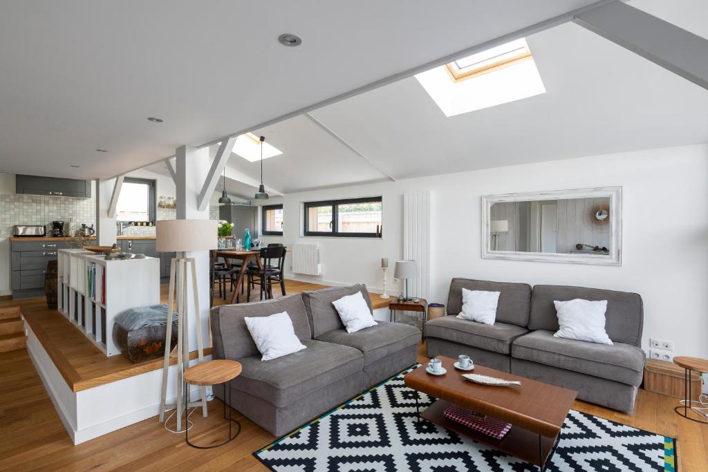 a living room with a couch and a table at Villa Emeraude by Cocoonr in Saint-Briac-sur-Mer