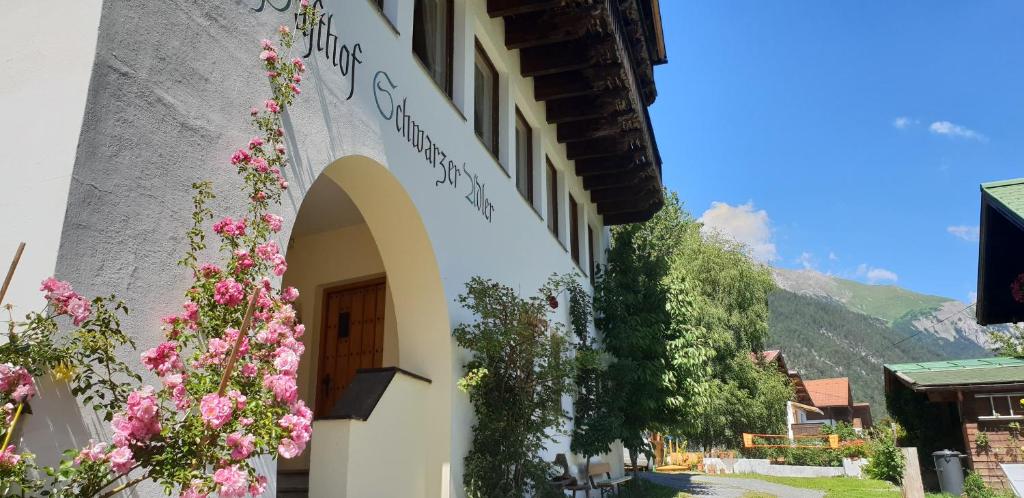 a building with flowers on the side of it at Hotel Schwarzer Adler in Pettneu am Arlberg