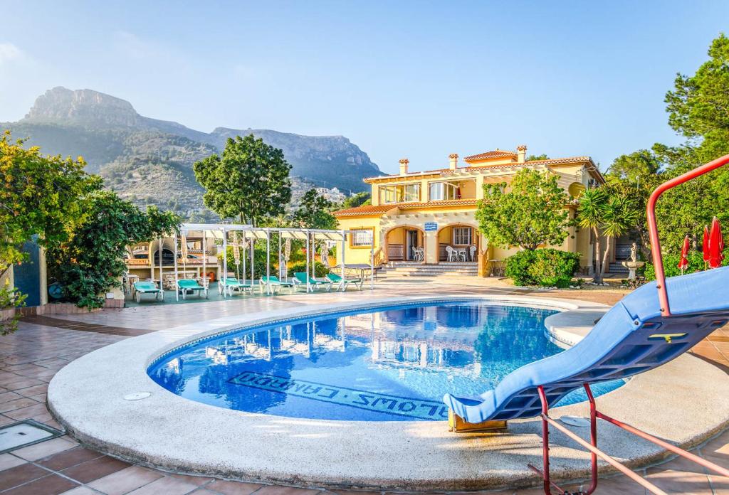 una piscina con un tobogán frente a una casa en Bungalows Canadá Alquileres Vacacionales, en Calpe