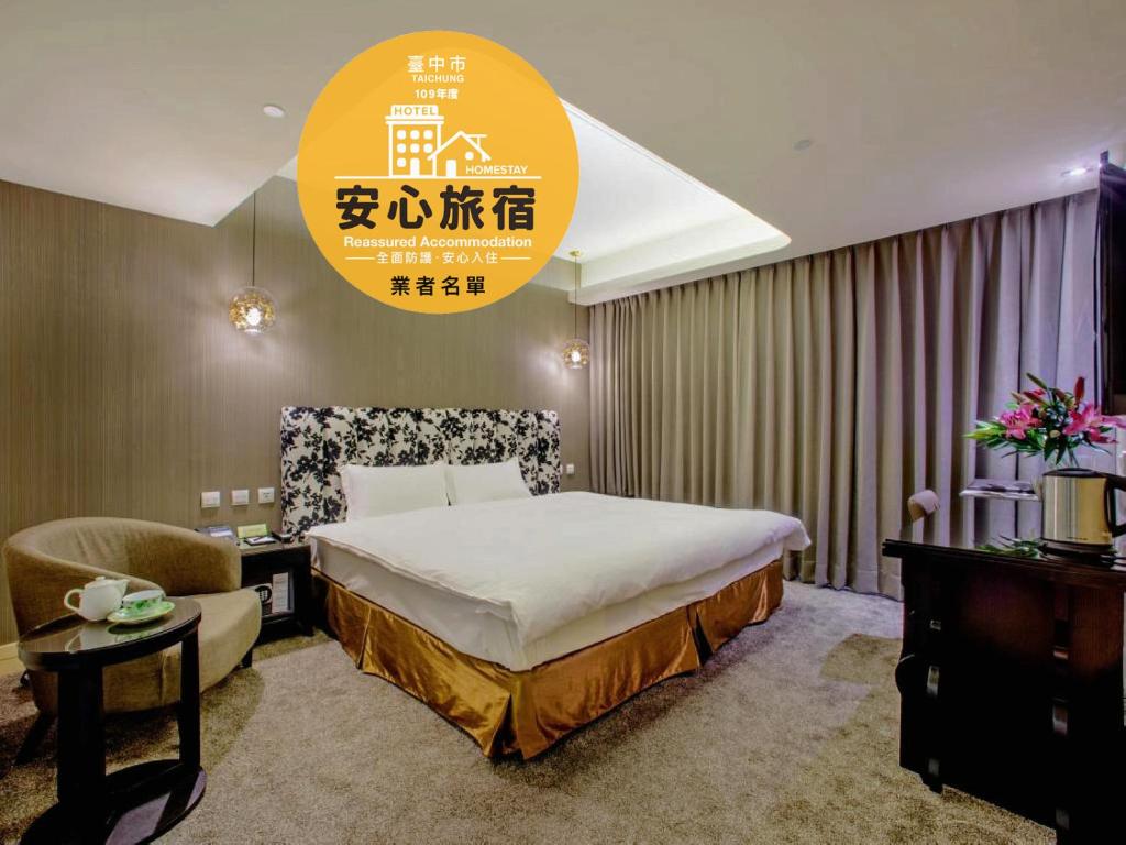 Habitación de hotel con cama y silla en Stay Hotel - Taichung Yizhong en Taichung