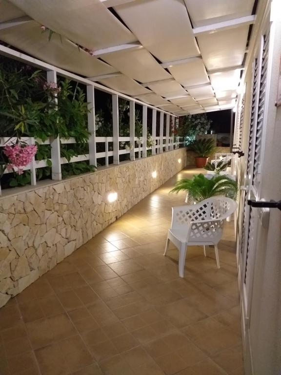 un balcón con un banco blanco y plantas en A Casa di Vera, en Punta Secca