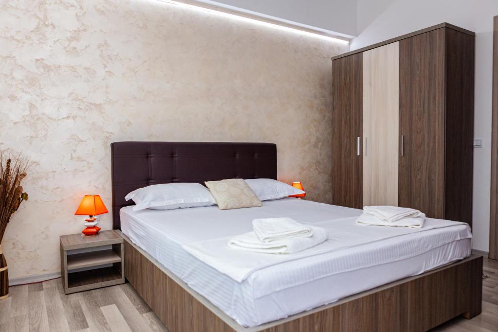 een slaapkamer met een groot bed met een zwart hoofdeinde bij Summerland Sea View Apartment in Mamaia