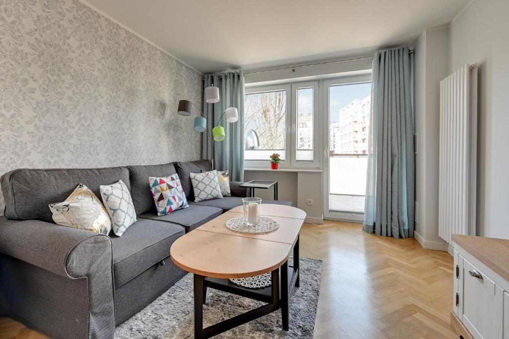 a living room with a couch and a table at Wave Apartments - Grobla Old Town in Gdańsk