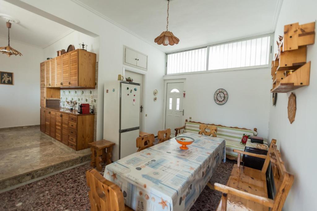 uma cozinha com uma mesa e cadeiras e um frigorífico em villa nicol em Corinto