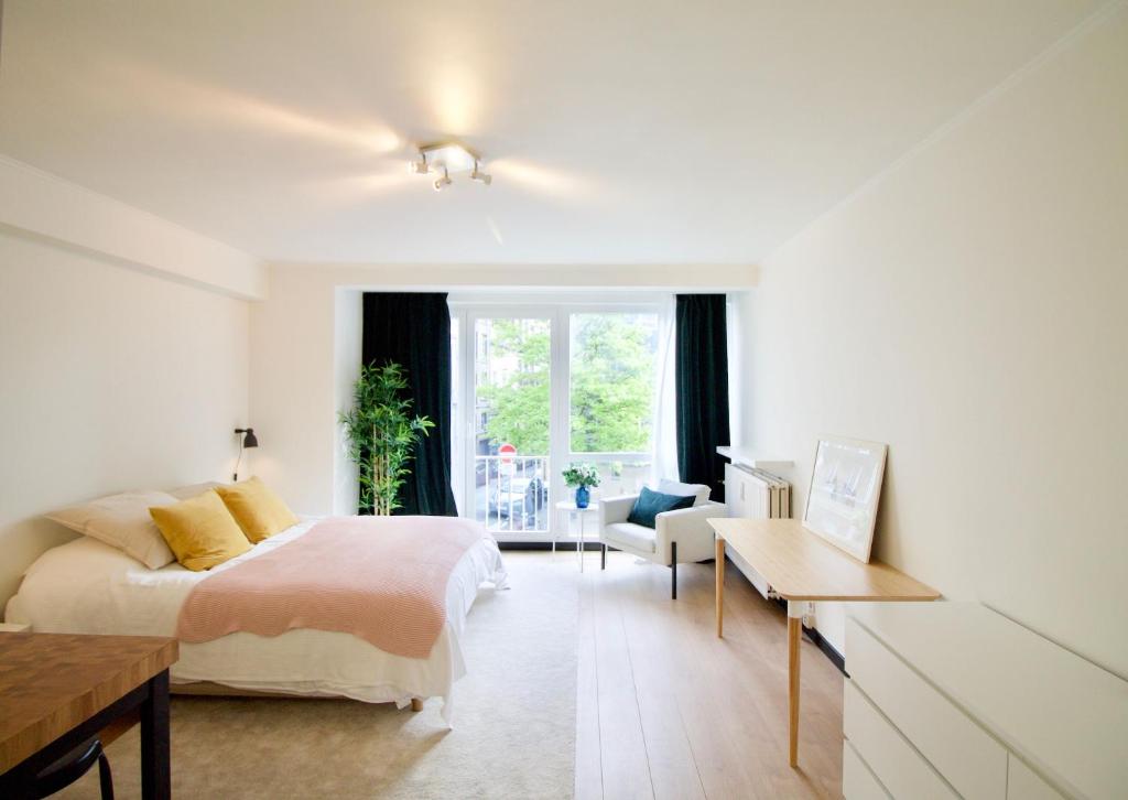 ein Schlafzimmer mit Bett, Schreibtisch und Fenster in der Unterkunft Splendid & cosy studio - perfect location 'Stephanie-Louise area' in Brüssel