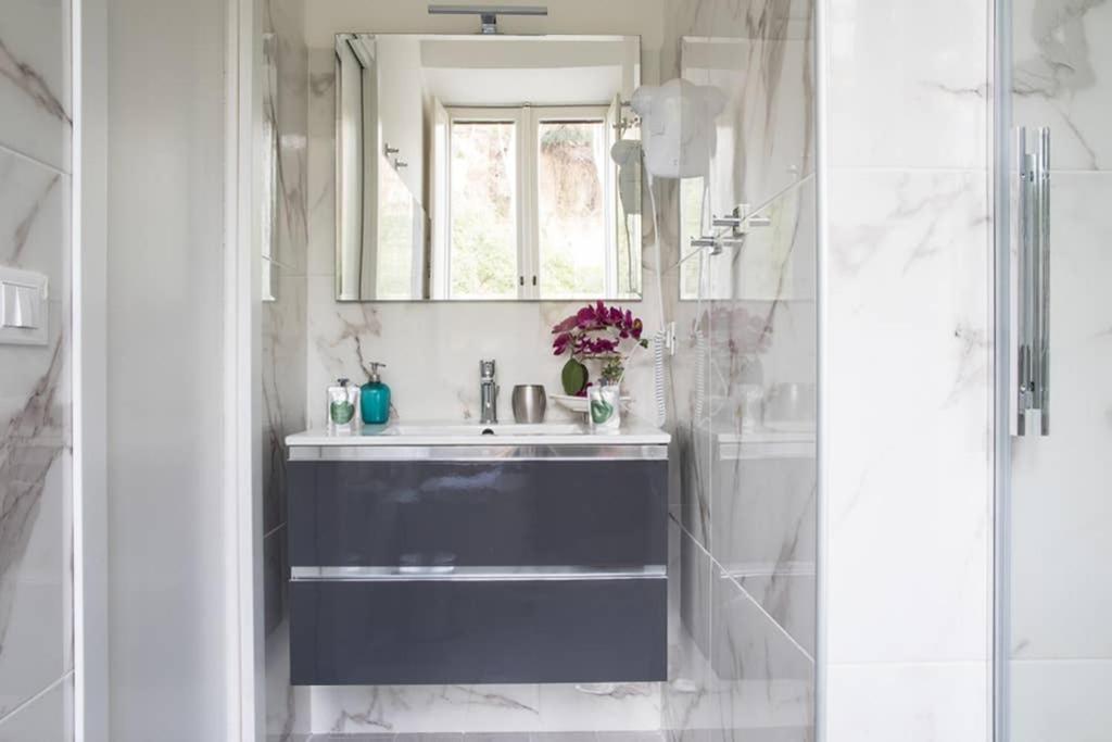W łazience znajduje się niebieska umywalka i lustro. w obiekcie Silver Luxury Jacuzzi Suite Trastevere - Top Collection w Rzymie