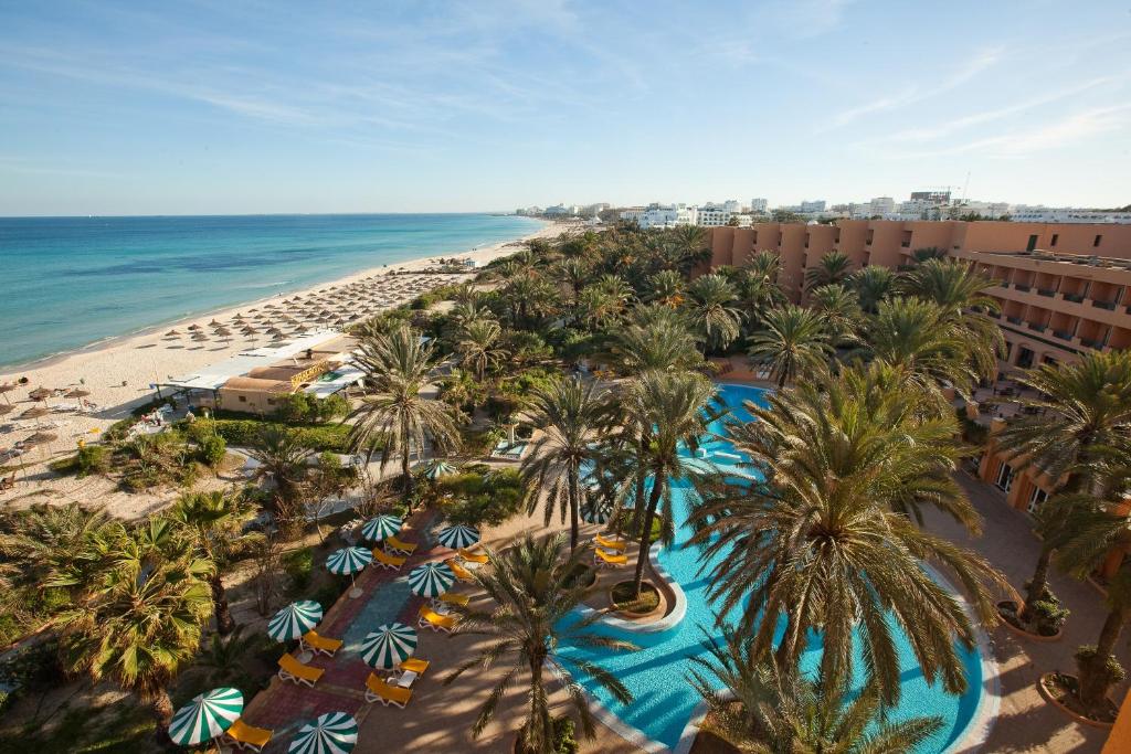 an aerial view of a resort with palm trees and the beach at El Ksar Resort & Thalasso in Sousse