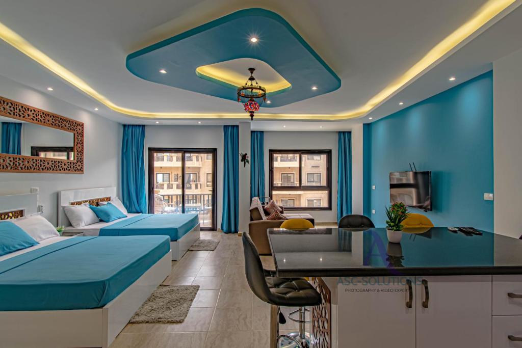 een hotelkamer met 2 bedden en een blauwe muur bij SeaView Turtles in Hurghada