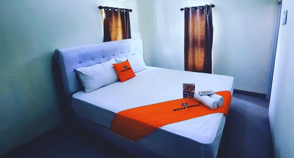 a small bedroom with a bed with an orange and blue at WISMA ANDALI Syariah near RSUD Cideres in Majalengka