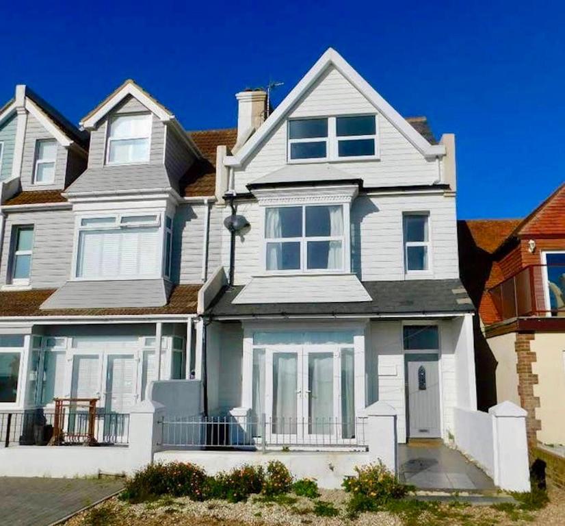 a large white house with white windows at Beautiful 4 Bed Beach House in Pevensey