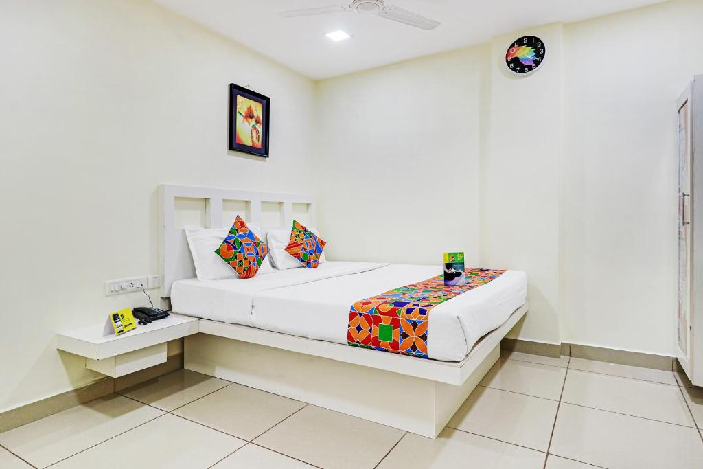 a white bedroom with a bed in a room at FabHotel Colors Service Apartment in Chennai