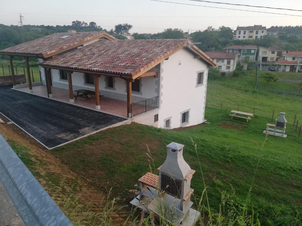 une petite maison blanche avec un toit dans l'établissement Los fresnos de ribadesella 4 personas, à Ribadesella