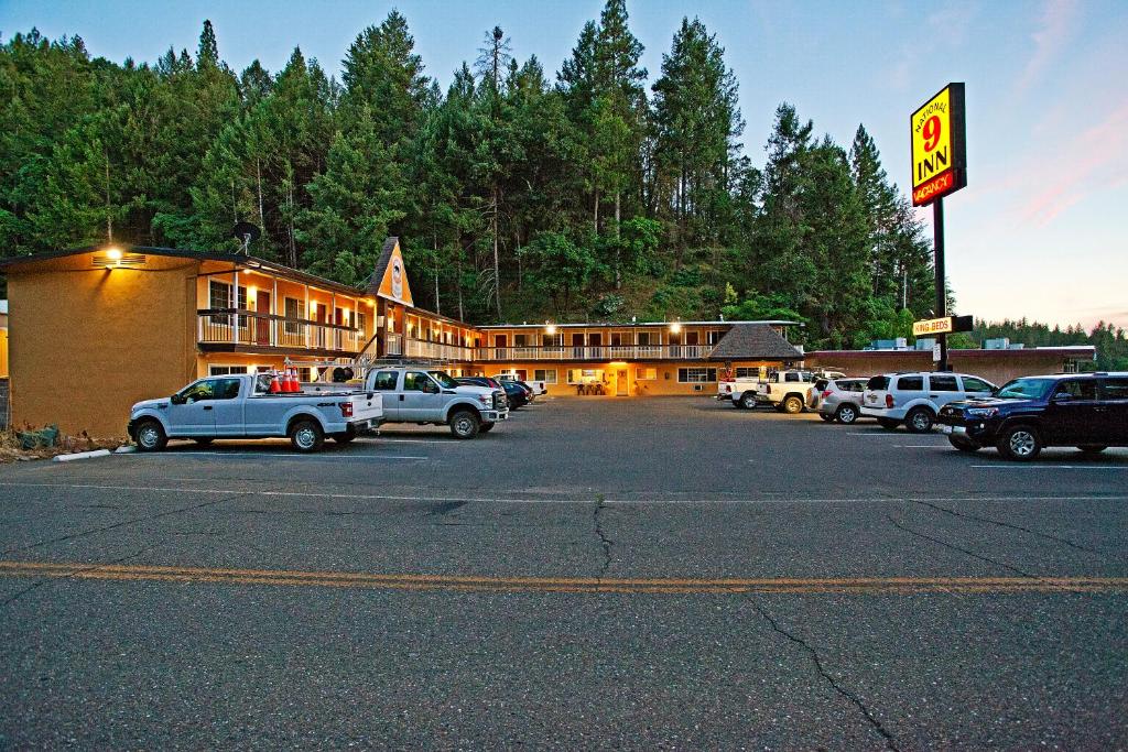 un estacionamiento con coches estacionados frente a un hotel en National 9 Inn - Placerville, en Placerville