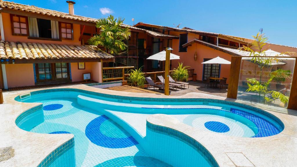 a swimming pool in front of a house at Sobrado da Vila Hotel in Praia do Forte