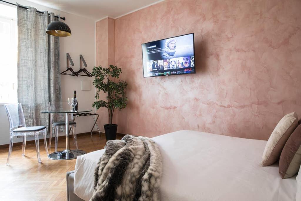 a living room with a bed and a tv on a wall at Pink Intimate Jacuzzi Suite Trastevere - Top Collection in Rome