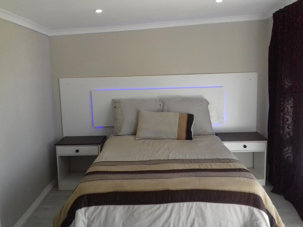 1 dormitorio con 1 cama con 2 mesitas de noche en High view accommodation en East London