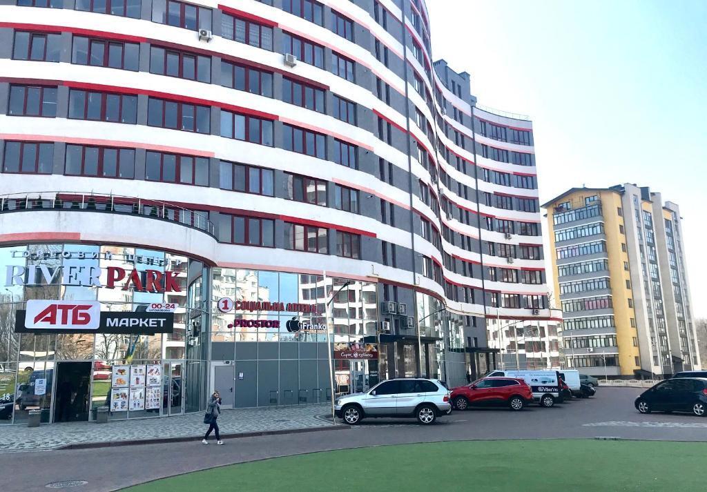 un grande edificio con auto parcheggiate in un parcheggio di ONE BEDROOM APARTMENT in IF city :) a Ivano-Frankivsʼk