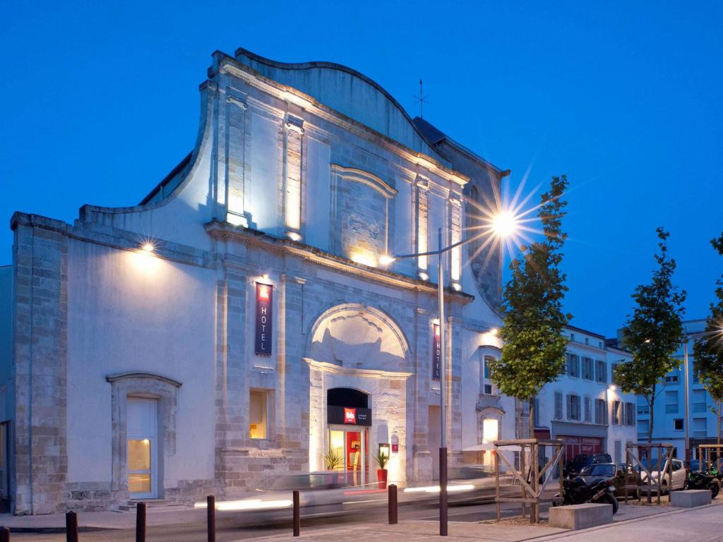 um edifício antigo com uma luz de rua em frente em ibis La Rochelle Vieux Port em La Rochelle