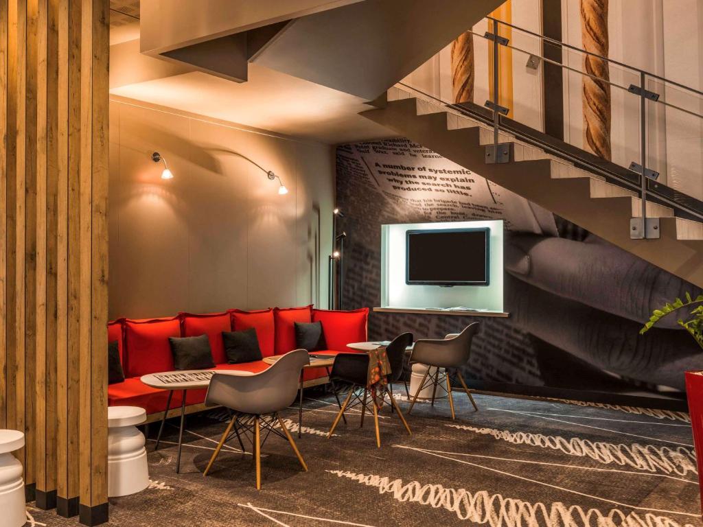 a waiting room with red chairs and a staircase at ibis Paris Montmartre Sacré-Coeur in Paris