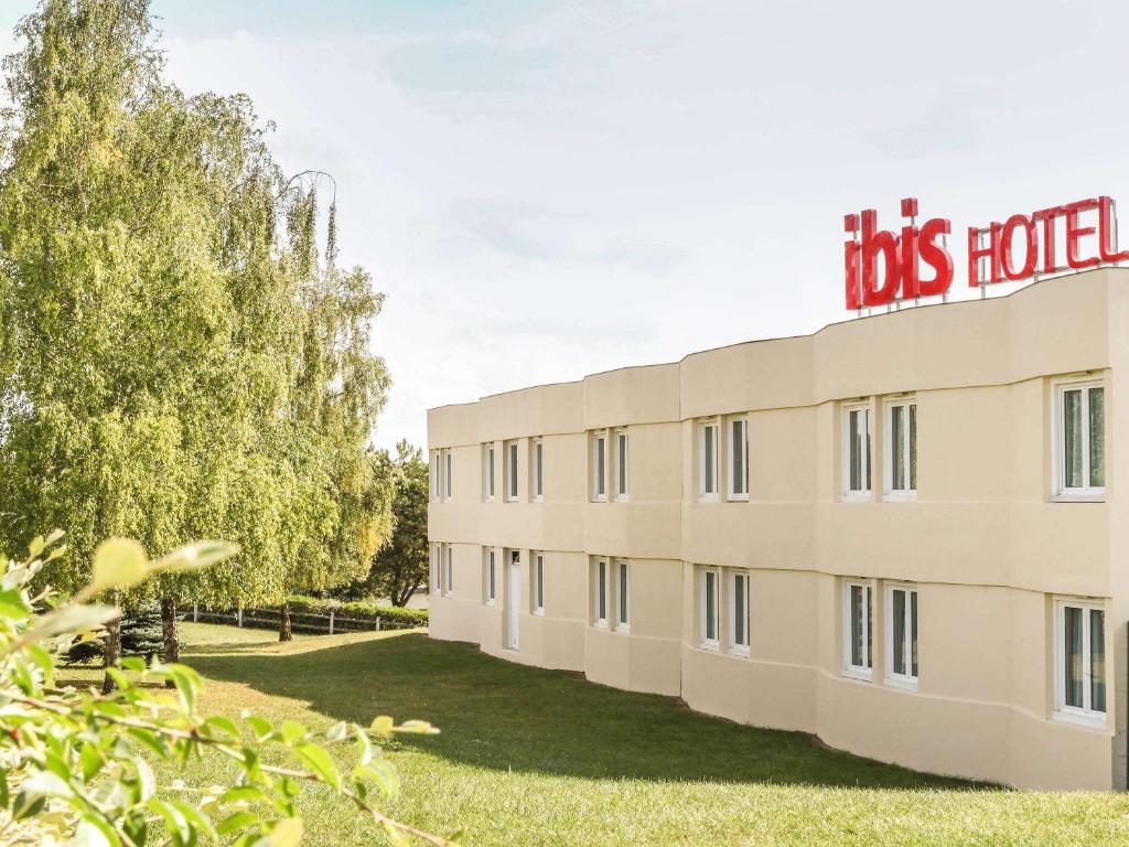 un bâtiment avec un panneau d'hôtel pour chiens dans l'établissement ibis Chalons en Champagne, à Châlons-en-Champagne
