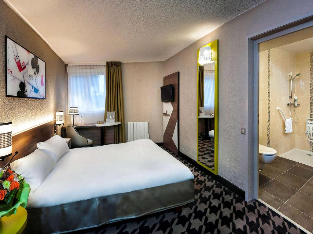 バランタンにあるibis Styles Rouen Nord-Barentinの大きなベッドとバスルームが備わるホテルルームです。