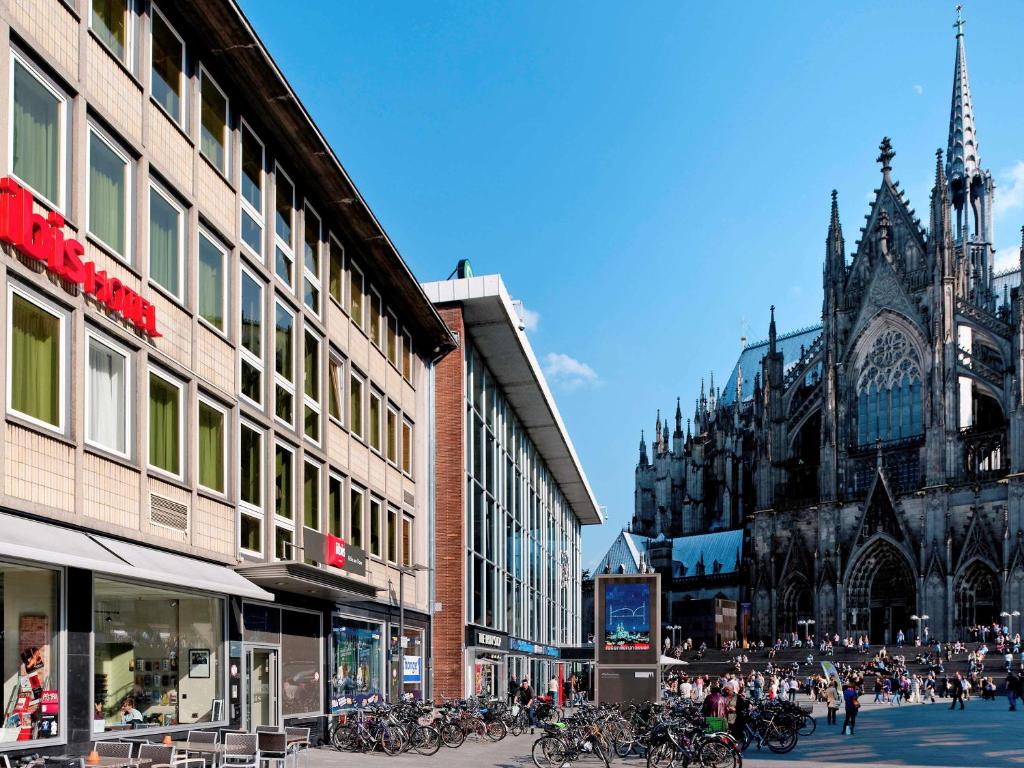 uma rua da cidade com muitos edifícios e uma catedral em Ibis Hotel Köln Am Dom em Colônia