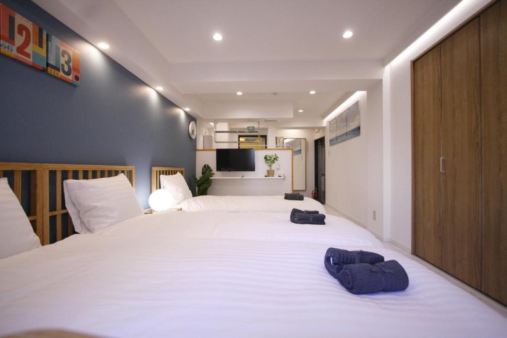 a bedroom with a large white bed with two towels on it at STAY ARI Kabukicho in Tokyo