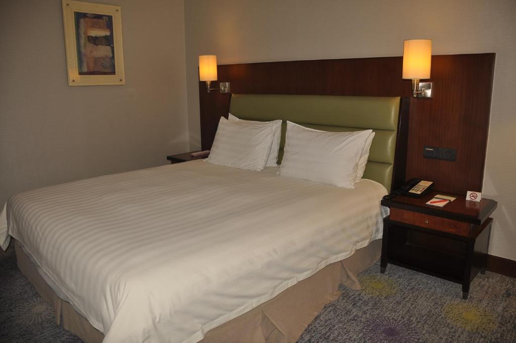 Postel nebo postele na pokoji v ubytování Ramada Plaza Pudong Shanghai