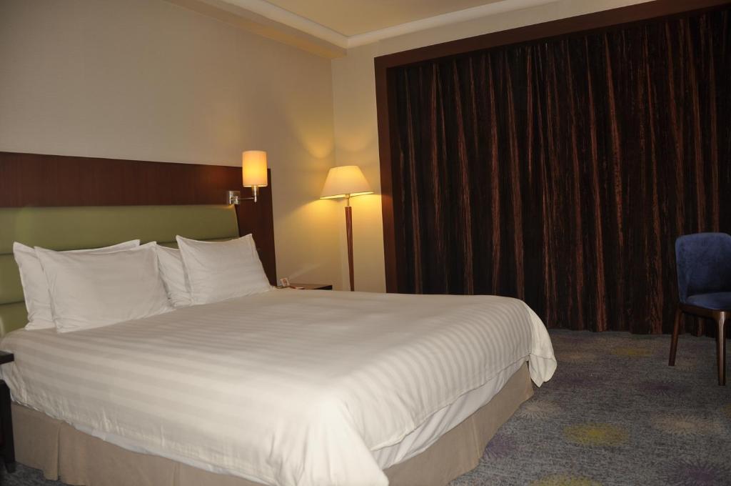 Postel nebo postele na pokoji v ubytování Ramada Plaza Pudong Shanghai