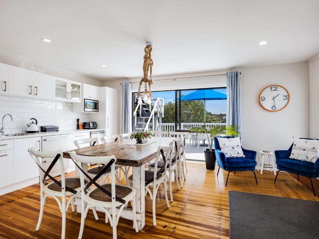 a kitchen and dining room with a table and chairs at Kiwi House Waiheke in Oneroa