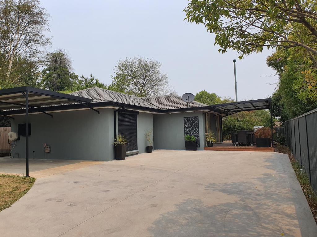 a detached garage with awning and a driveway at Belle in bowral in Bowral