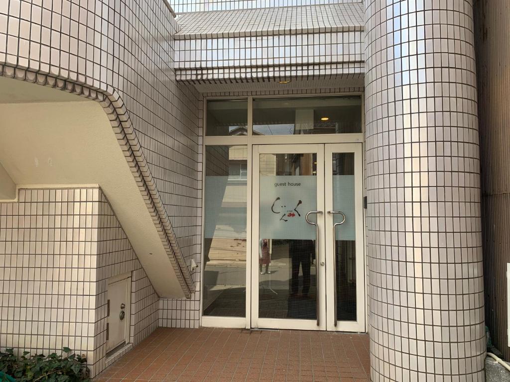 佐渡市的住宿－Guesthouse Zink，玻璃门进入大楼的入口