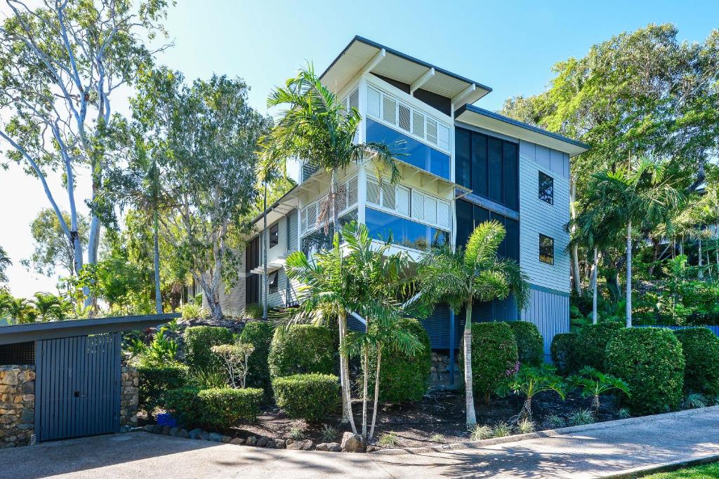 ein Haus mit Bäumen und Büschen davor in der Unterkunft Oasis Apartments on Hamilton Island by HIHA in Hamilton Island