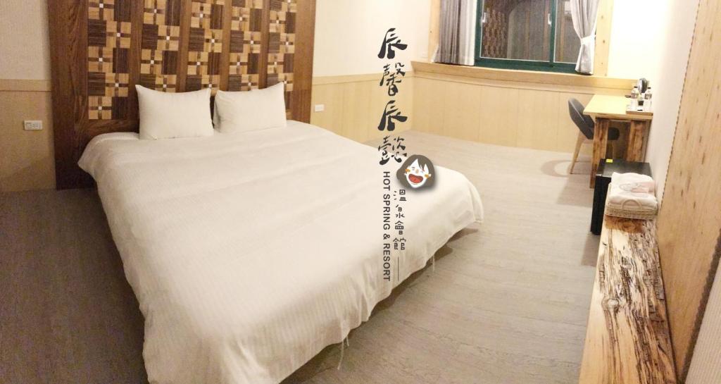 a bedroom with a large bed with writing on it at 沐馨溫泉民宿 in Jiaoxi