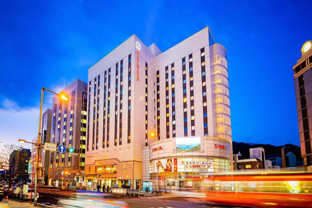 a large building on a city street at night at Matsuyama Tokyu REI Hotel in Matsuyama