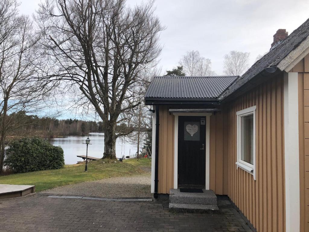 ein Gebäude mit einer Tür und Seeblick in der Unterkunft Naturskönt boende vid Sjö in Skånes Fagerhult