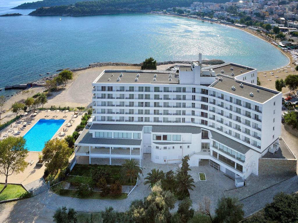 eine Luftansicht eines großen weißen Gebäudes neben dem Wasser in der Unterkunft Lucy Hotel in Kavala