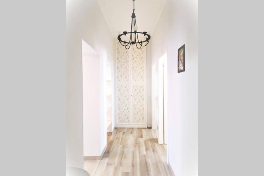 pasillo con puerta y lámpara de araña en Delizioso appartamento cosy ristrutturato en Parma