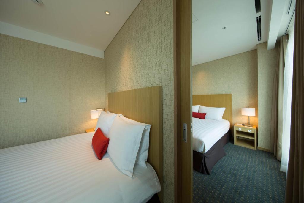 Postel nebo postele na pokoji v ubytování Solaria Nishitetsu Hotel Busan