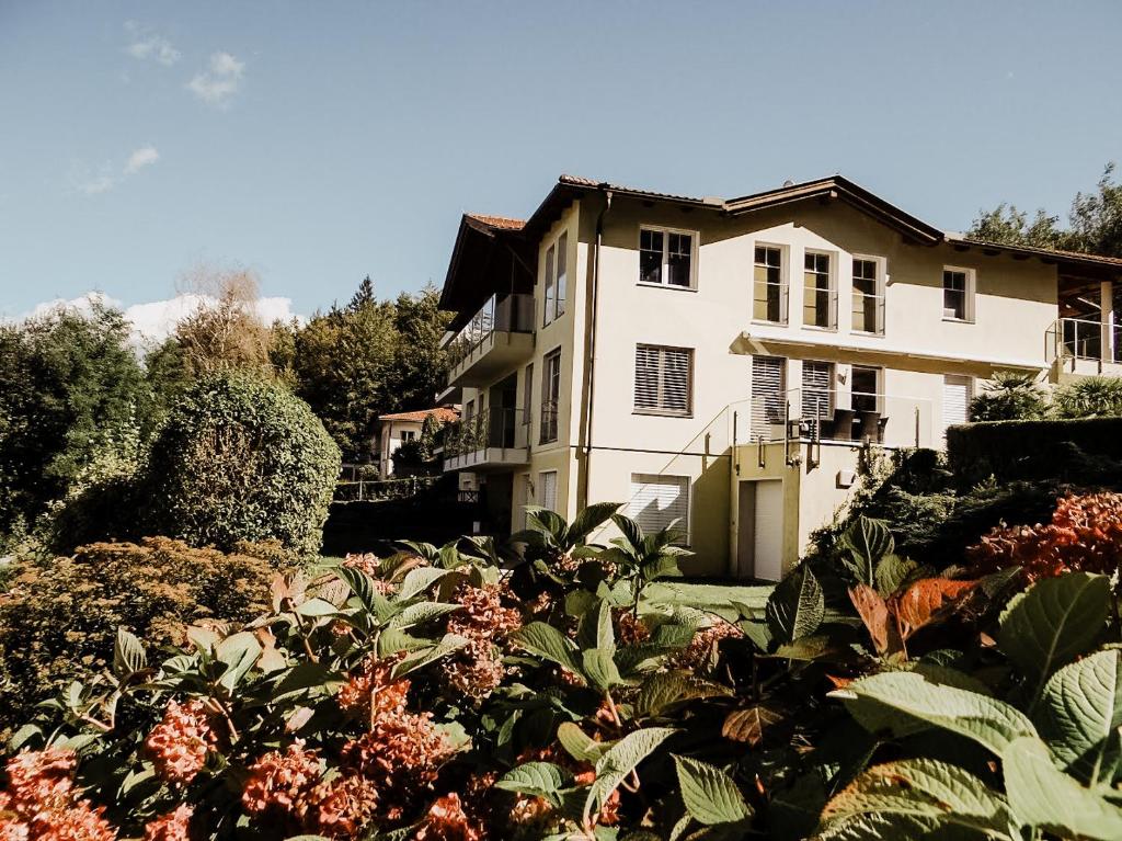 a white house with a garden in front of it at Lake View Apartment Seecorso in Velden am Wörthersee