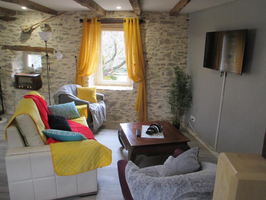 Beynat的住宿－La Ferme de la Chapelle-Saint-Jean，客厅配有两张沙发和一张桌子