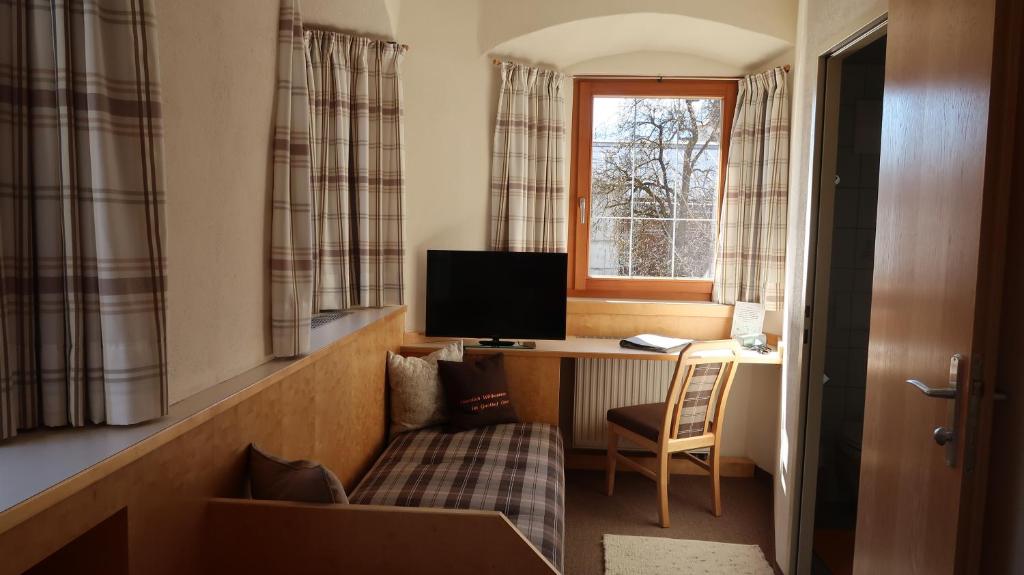 a room with a desk with a computer and a window at Hotel Garni Löwen in Silz