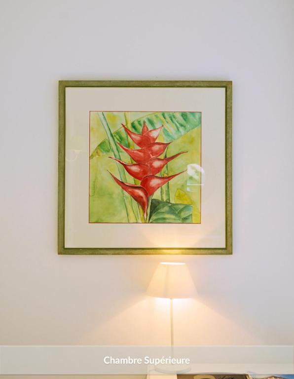 a framed painting of a red flower on a wall at Hôtel & Espace Bien-être La Maison du Lierre in Biarritz