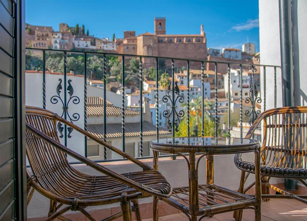 een balkon met 2 stoelen en een tafel en uitzicht op de stad bij Casa Rural la Llar in Vilafames