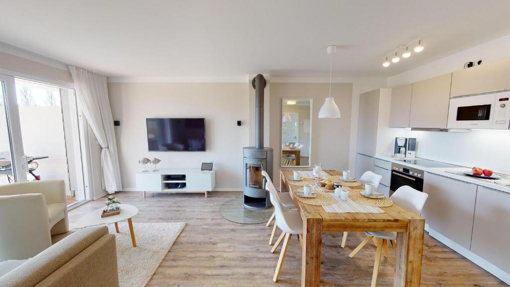 a kitchen and a living room with a table and chairs at Beach'n'Sea Wohnung 2 in Grömitz