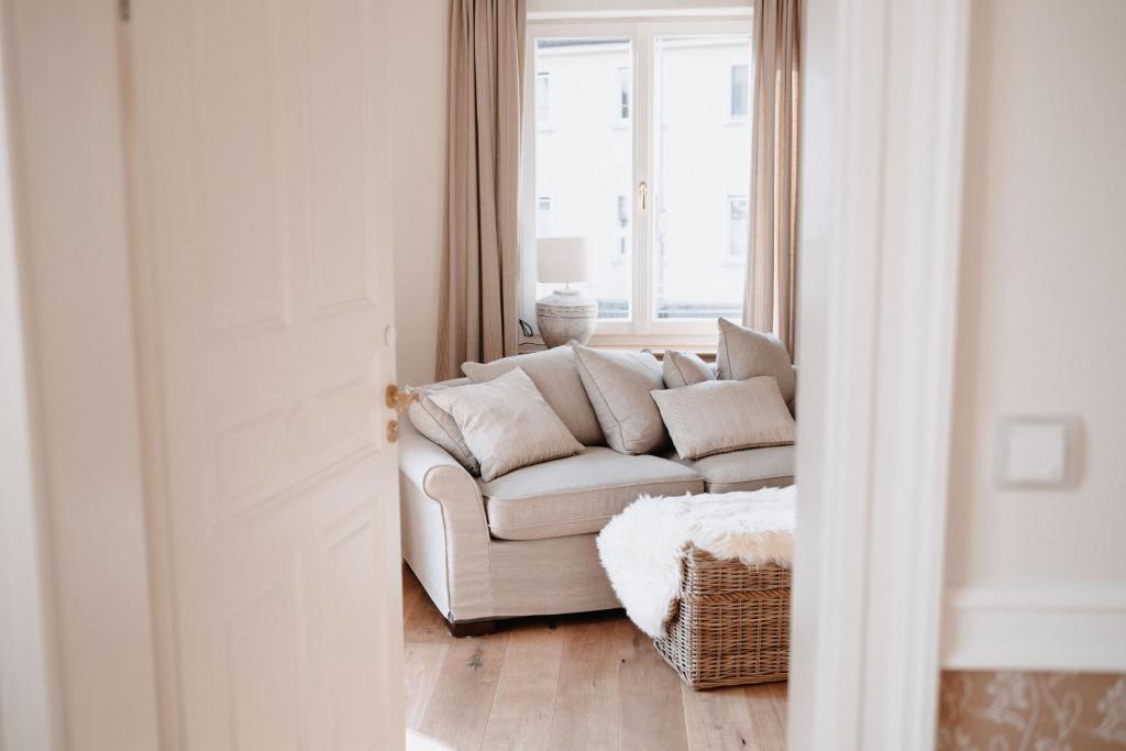 a white couch in a living room with a window at Das Betthupferl in Goldbach